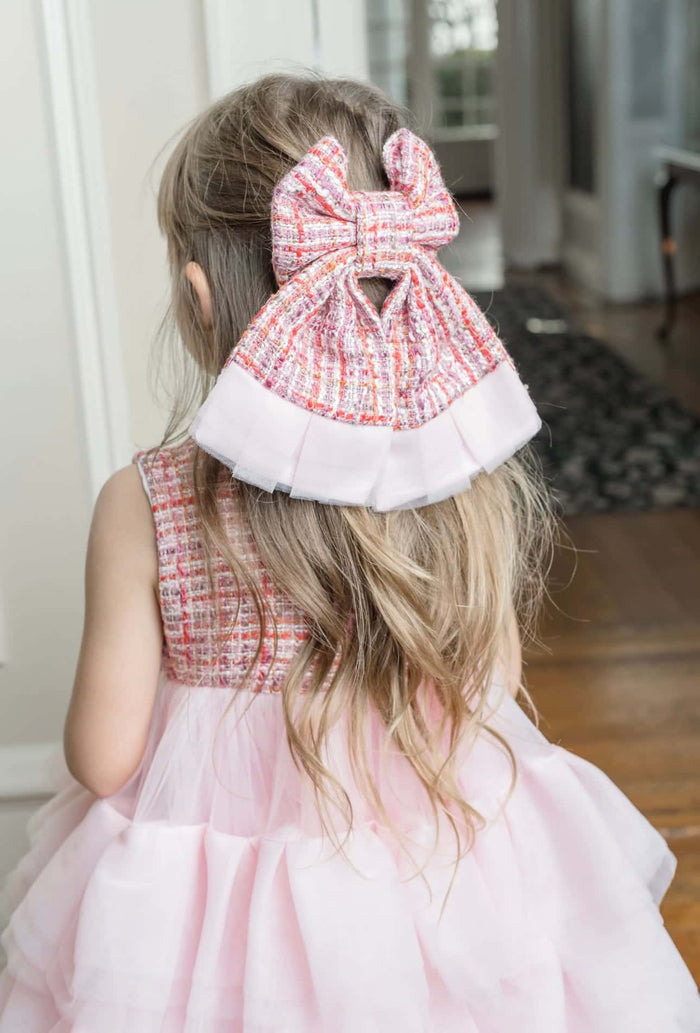Close-up back view of Kellie Pink Tweed Hair Bow highlighting structured bow loops, soft pink woven tweed, and layered tulle trim for a refined statement look.