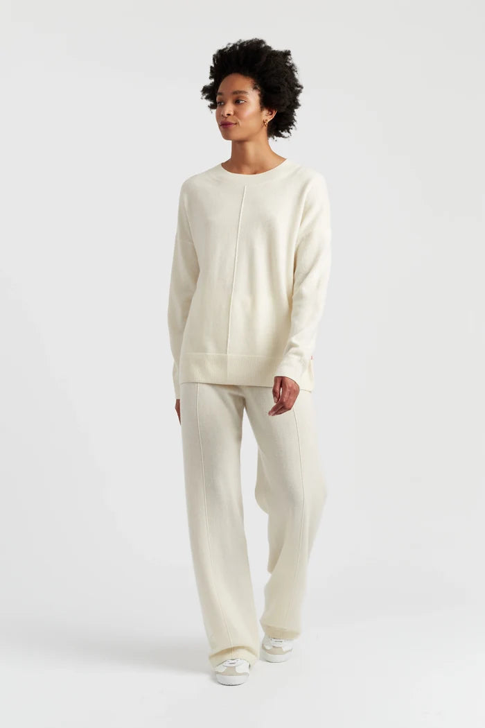 Woman wearing a cream-colored outfit on a white background