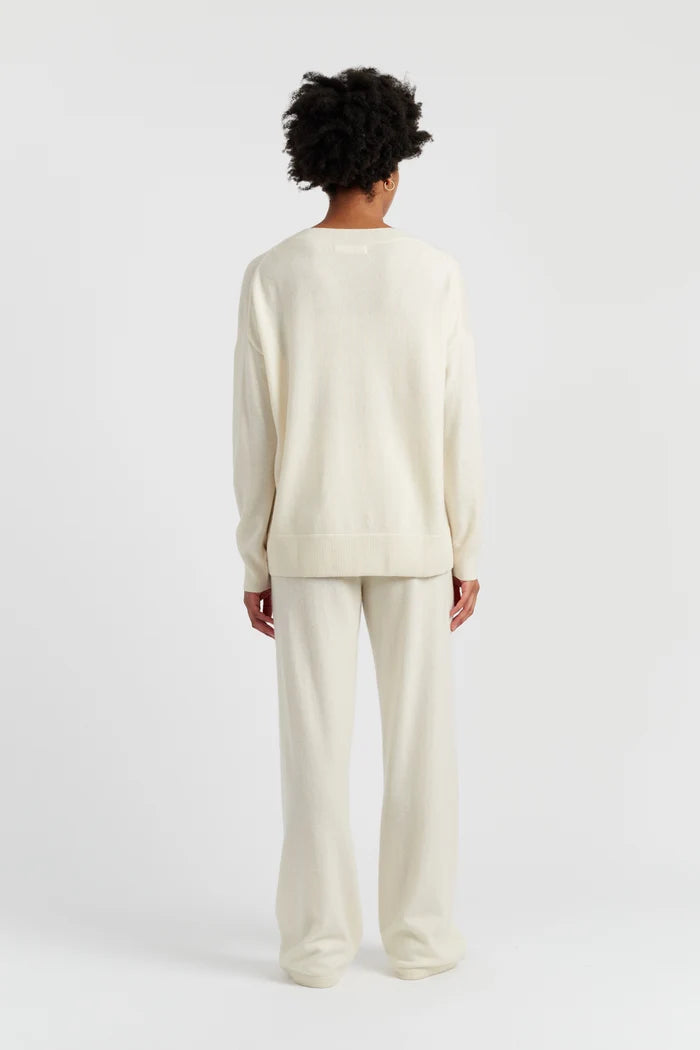 Person wearing a cream-colored outfit on a white background