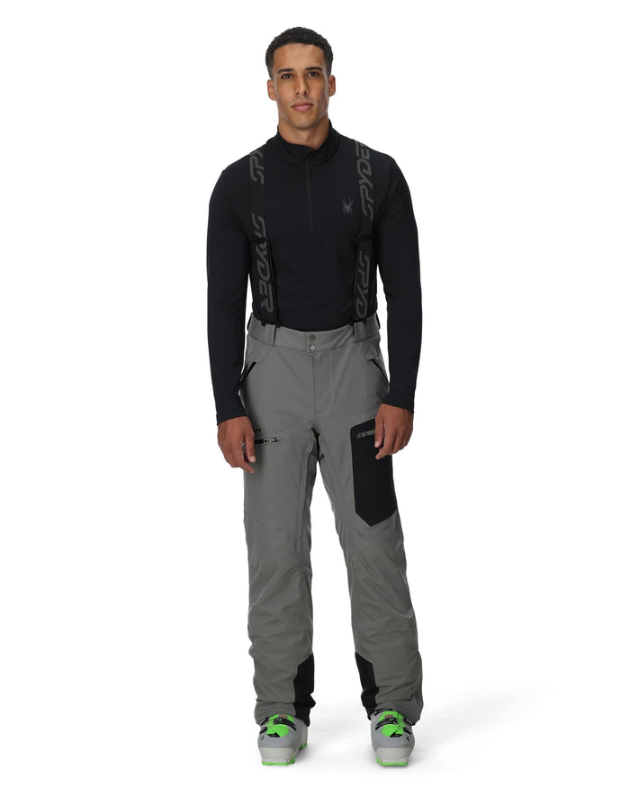 Person wearing a black long-sleeve top and gray pants with black accents on a white background