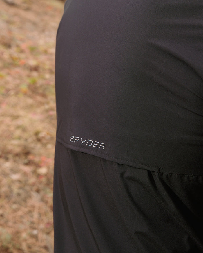 Black athletic outfit with Spyder branding on a blurred natural background
